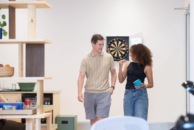 Picnic team members playing darts in the office