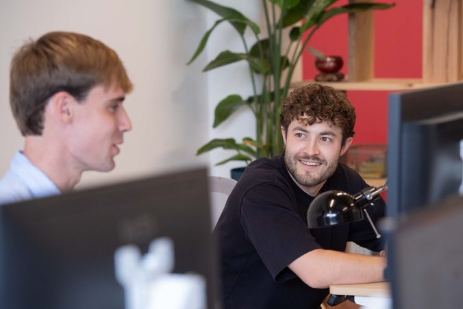 Two Picnic colleagues chatting at a desk